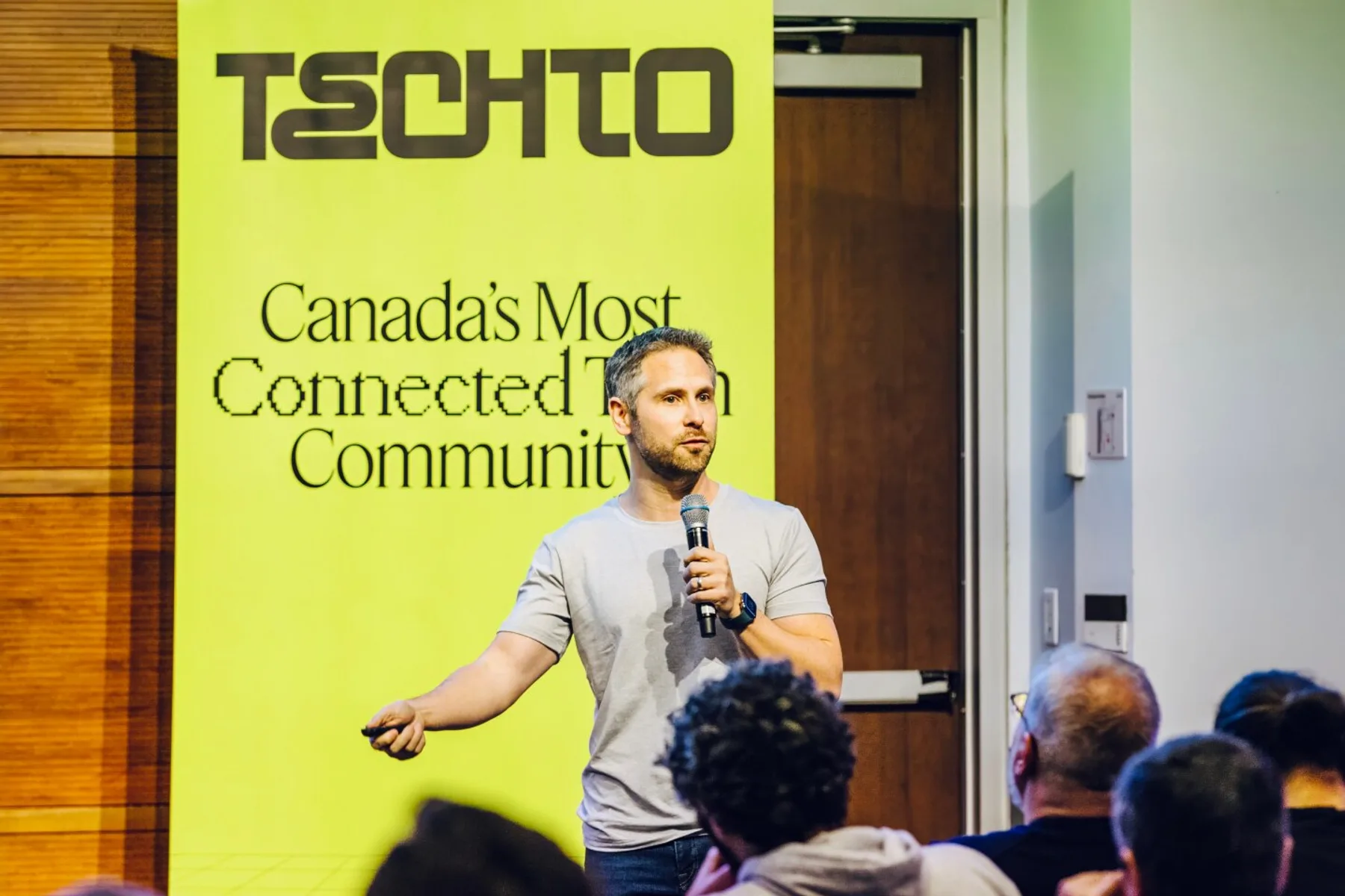 TechTO: a speaker addressing an audience in front of the brand's lime wall